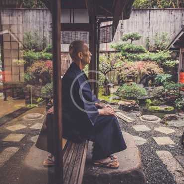 Japanese man meditating in his garden